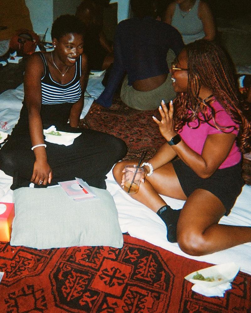 Two guests laughing together on a rug