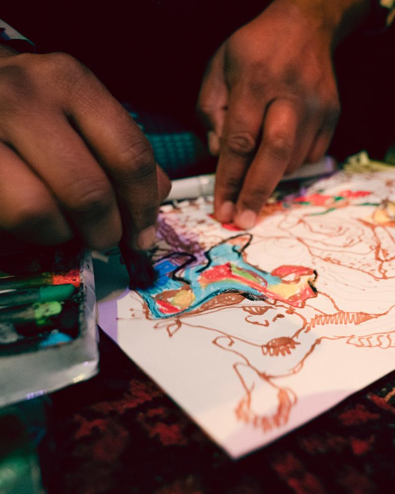 Hands adding colour to a drawing at a workshop
