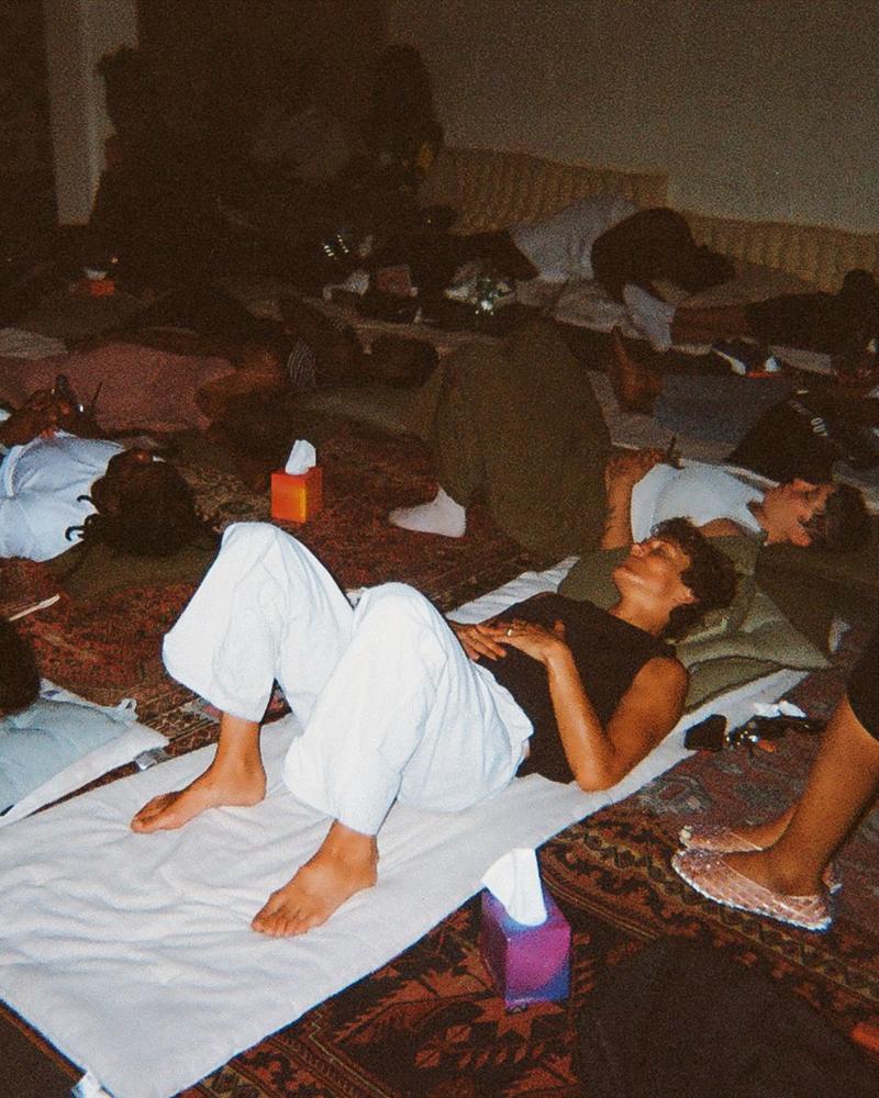 Guests lying on rugs and cushions during a listening session