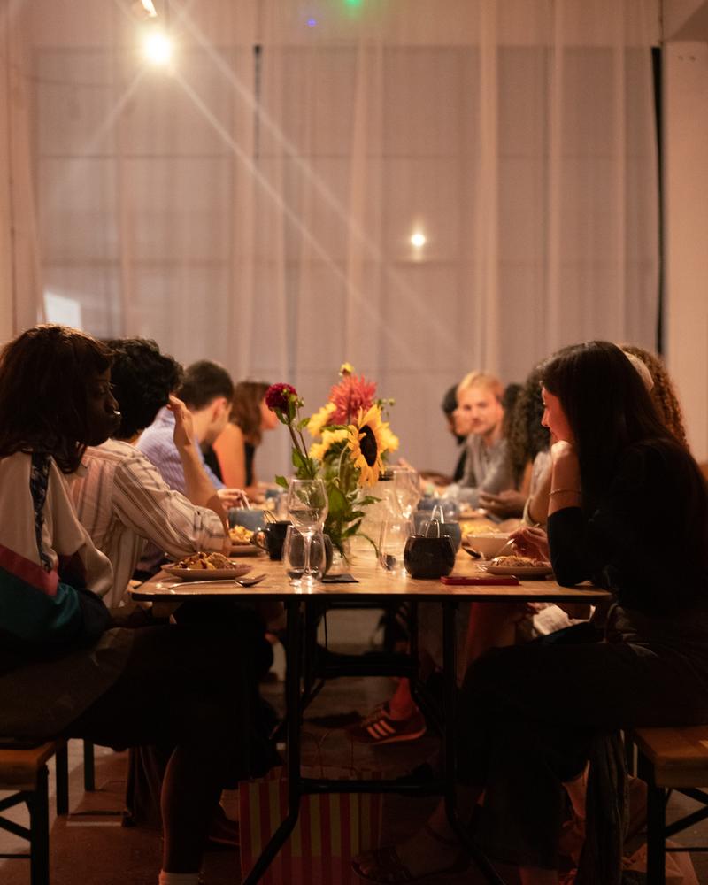 Guests at a long dinner table with flowers